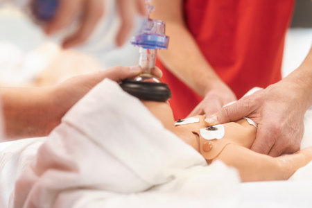 Hands of paramedic of emergency medical service during training resuscitation training on newborn dummy.の写真素材