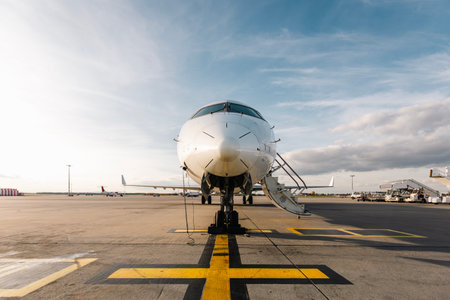 Front view of airplane on ground waiting to be boarded. Plane at airport on sunny day.の写真素材