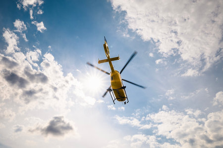Flying helicopter of emergency medical service on sky on sunny day. Themes urgency, rescue and hope.の写真素材
