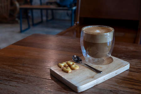 Cappuccino in a clear glass, rich color, beautifully served with crisp crackers.の写真素材