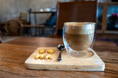 Cappuccino in a clear glass, rich color, beautifully served with crisp crackers.の写真素材