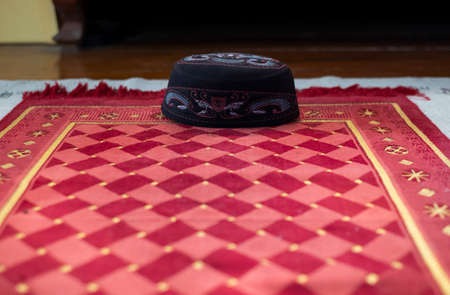 Black Islamic hat placed on the mats used in the ceremony.の写真素材