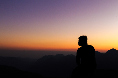 Man with arms extended toward heaven at sunrise ,success or prayer conceptの写真素材