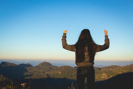 Woman expressing freedom on mountainの写真素材