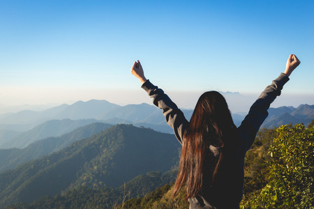 Woman expressing freedom on mountainの写真素材