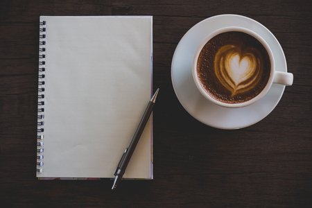 Blank notebook on the coffee table, latte art の写真素材
