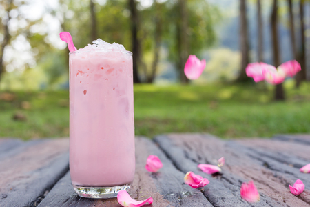 Ice tea with rose milk on wooden tableの写真素材