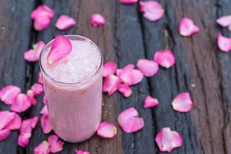 Ice tea with rose milk on wooden tableの写真素材