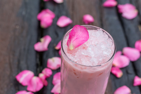 Ice tea with rose milk on wooden tableの写真素材