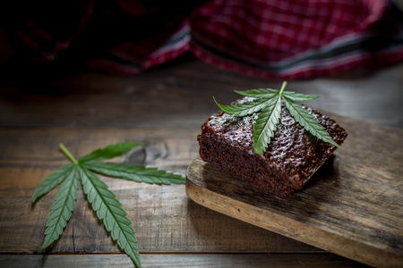 marijuana leaf on a marijuana brownie on wooden tableの写真素材