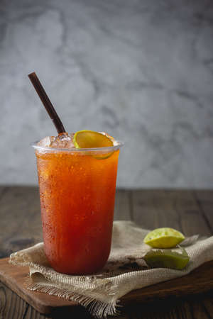 ice tea with slice of lemon in plastic cup on the wooden  background