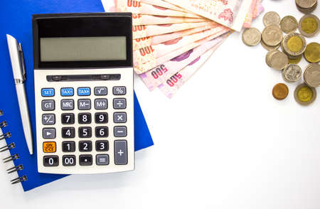 Calculator with money and Notebook on white background,top view,copy space