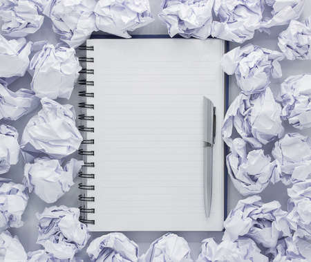 White note pad on white background. Around the notepads lies lot crumpled paper,Copy spaceの写真素材