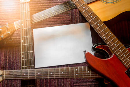 The stacked guitars and sheets of paper put the text.Copy spaceの写真素材