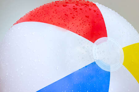Drops of water on a beach ball with red, yellow, blue and white, beach balls that communicate with summer.の写真素材
