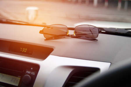 The concept of using sunglasses during travel : Sunglasses used in cars : Close up sunglasses placed...