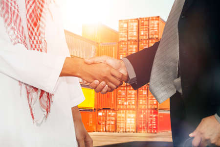 Confirm successful success between Asian businessmen and business partners, Arab male businessmen, business cooperation, export and import of sustainable productsの写真素材
