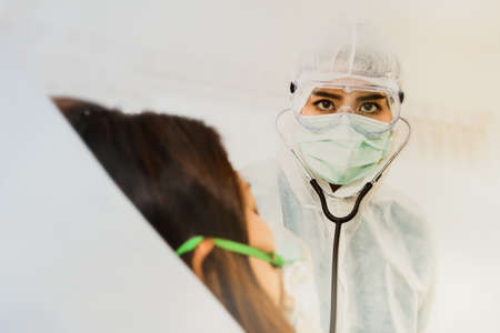 The female doctor responsible for the care of influenza patients has the intention to treat the coronavirus pandemic in the hospital room.Look at the camera with determinationの写真素材