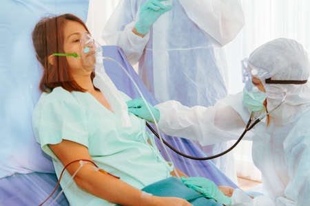 Medical team for treatment of coronavirus (covid-19) A young woman infected with an outbreak uses a...
