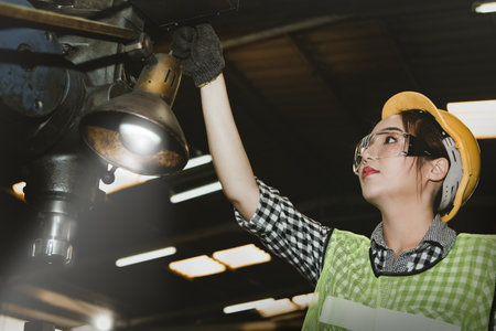 Female technicians control the work of the electric drill, check the neatness and safety before...
