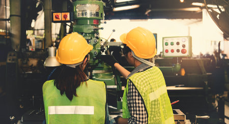 Back view Female teamwork technicians, operators and female assistants operate the control panel of the electric steel drill and inspect the safety operation.の写真素材