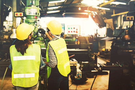 Female technician, operator and female assistant operate control panel, drill machine, electric power system and inspect, understand safety operation, industrial work, engine parts : Selective Focusの写真素材