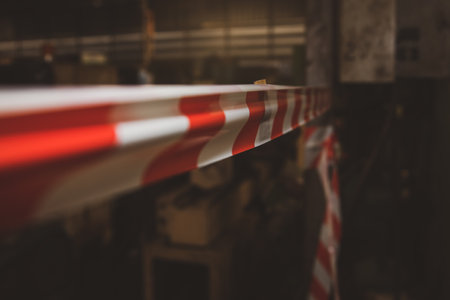 Hazardous areas and restricted areas within industrial plants are installed with sticky white warning tape, red warning symbol and caution.の写真素材
