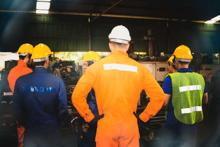 Rear view group of industrial technicians wear safety work clothes to be effective :  Meeting was delegated according to the duties of the mechanic in the industrial engineering department.の写真素材