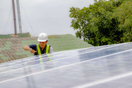 Engineers check the tightness and safety of solar panels while installing the new structures on the roof of an industrial plant : Selective Focusの写真素材