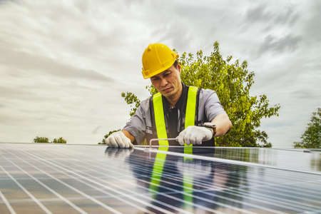 Technicians work for safety : Electrical technician using tools
Hexagon wrench to check the installation for the tightness of the solar panel attached to the rigid structure on the roof deck.の写真素材