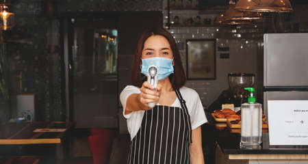 Coffee Shop Business Woman Employee Body Temperature Monitor Customer Service During virus  Outbreak , Initial Defense New Normal : Selective Focusの写真素材