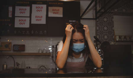 The stress of doing a coffee shop business : Business women suffer from headaches, income worries and financial stressの写真素材