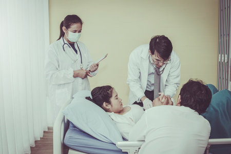 Caring for a pregnant woman by a team of expert pediatricians is examining the development of the baby in the stomach by her husband's expectations and close inside the room.の写真素材