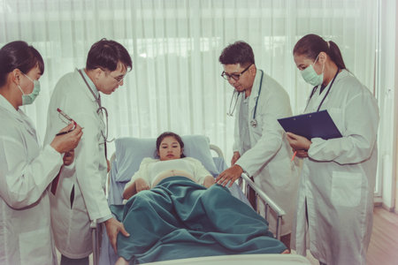 Working as a pediatrician team takes care of pregnant women near the end of their birth in the hospital's room and is expecting strong health.の写真素材