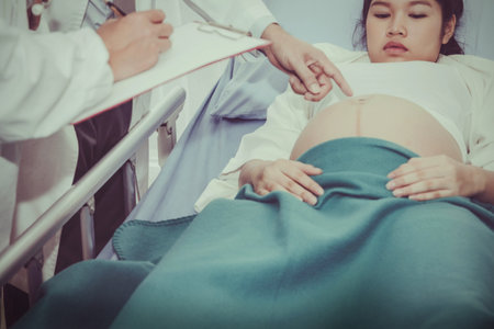 The doctor examined the pregnant woman near the end of the birth, indicating that she was healthy, both mother and baby in the stomach.の写真素材