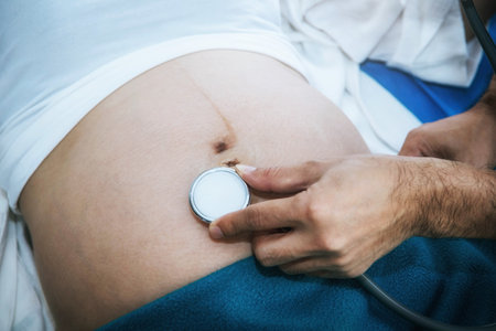 Closeup of the hands, the doctor uses a medical headset to hear the fetus and develop the baby's movement within the mother's stomach before birth.の写真素材