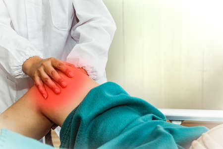Concept of health care for pregnant women : female doctor's hand takes care of the groin pain and the knees of the pregnant woman due to the weight gain of the baby each month. And admitted to the hosの写真素材