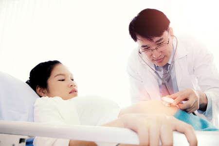 Male doctors, pediatricians use medical headsets to listen to the fetus and develop infant movements. Taking care of antenatal care, expecting mothers and children to have good health.の写真素材