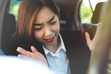 Portrait asian woman was shocked and unable to keep her mood while sitting in the car looking at the...