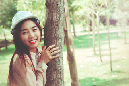 Happy female architects realize the importance of protecting the environment and the green space of trees for good health.の写真素材