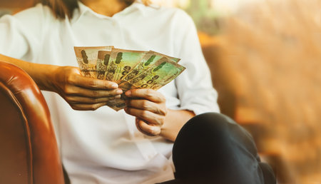 Femali sat to examine the count of the five thousand Thai bank notes in his hand to plan the money for daily life : Selective Focus : Copy Spaceの写真素材