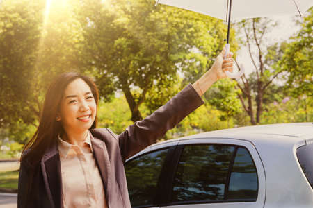 Portrait Asian business women use umbrellas to prevent ultraviolet (UVA) rays from the daylight in...