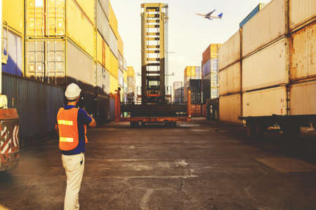 foreman controls the workers to tighten the crane, loading the central container, order the...
