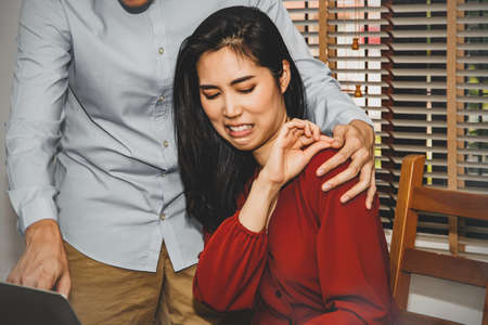 Concept harassment of women in the office : Beautiful woman uses her hand to prevent the harassment of a man who has no social etiquette while sitting in the office, and she has a very trashy manner.の写真素材