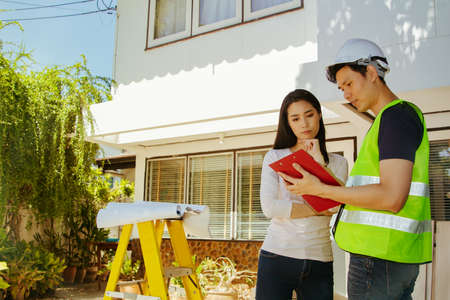 Male architect in charge of the project and the female owner standing in front of the house...