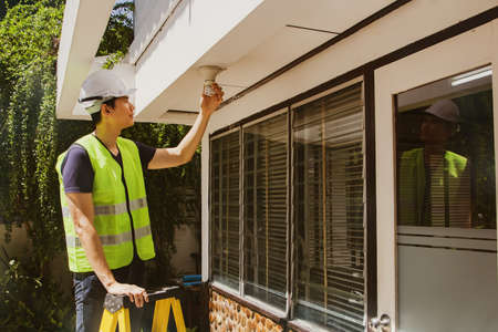 Electricians work on stairs to replace broken and damaged LED light bulbs and facades : Safe working conceptの写真素材