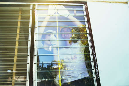 Couple helps to repair the house and work together to use a tape measure to measure the width of the windows, glass, shutters for renovation.: Outside view : Selective Focusの写真素材