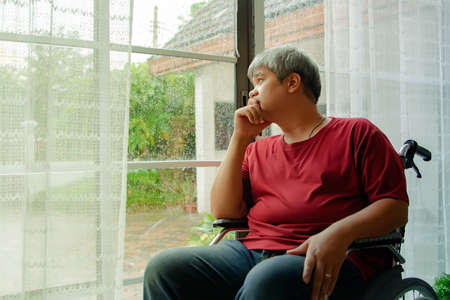 The fat man sat sadly, desperate for an illness that had no cure for walking the same, sitting alone in his home alone.の写真素材