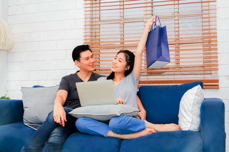 The couple rejoiced and enjoyed their family with the items in the paper bags ordered online.の写真素材