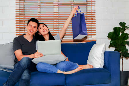 The couple rejoiced and enjoyed their family with the items in the paper bags ordered online.の写真素材